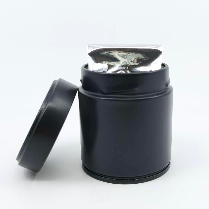 Black tea storage tin with sealed tea packet inside, ideal for preserving premium Japanese tea freshness