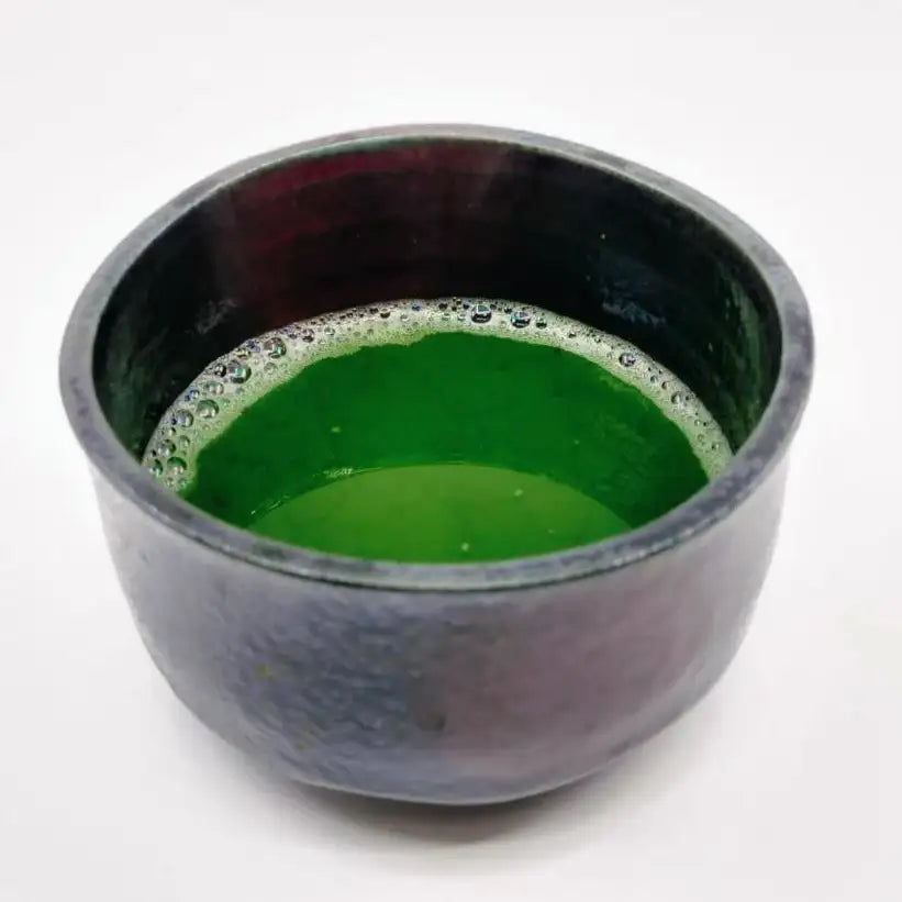 Vibrant green matcha tea in a handcrafted ceramic bowl, showcasing authentic Japanese tea culture.