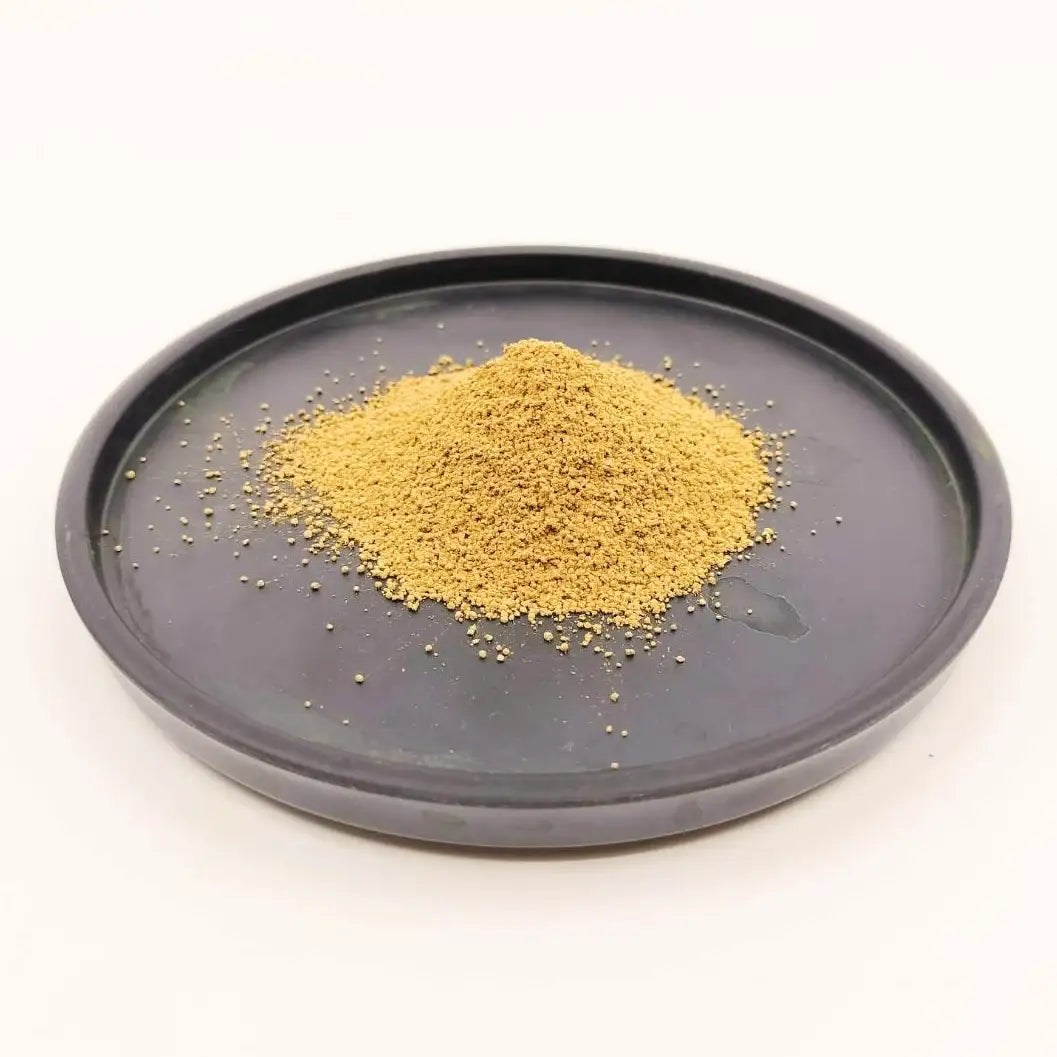 Fine Japanese matcha powder on a dark ceramic tray, showcasing premium tea texture