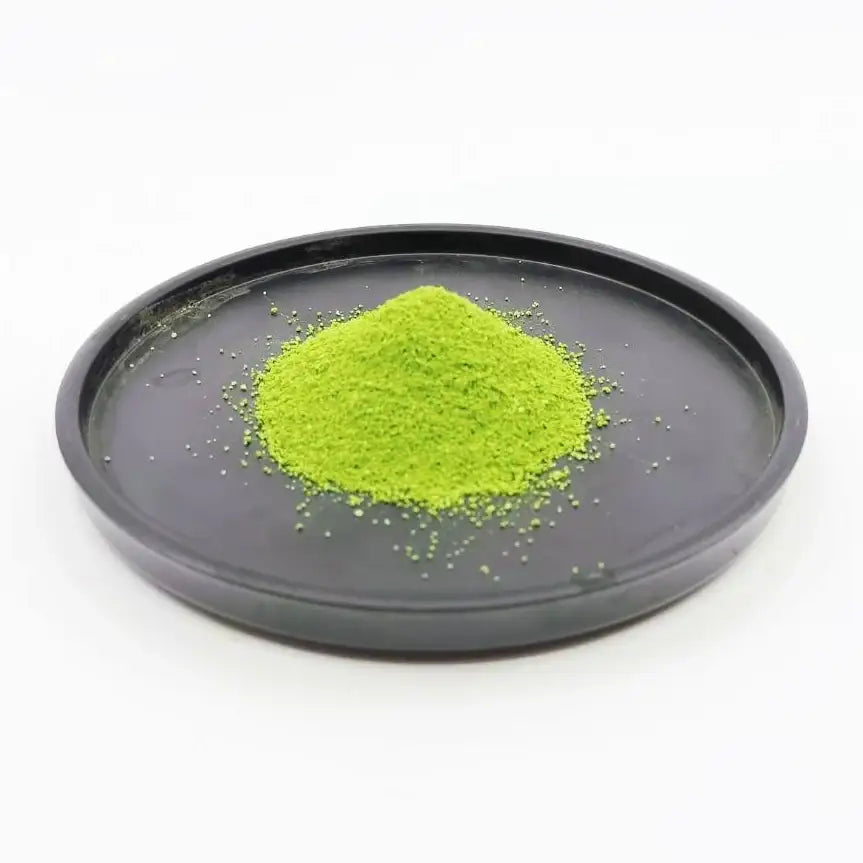 Vibrant green matcha powder on black tray, showcasing premium Japanese tea quality