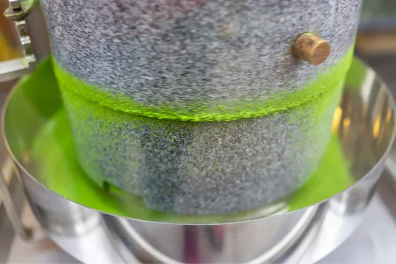 Stone mill grinding vibrant green matcha powder for premium Japanese tea