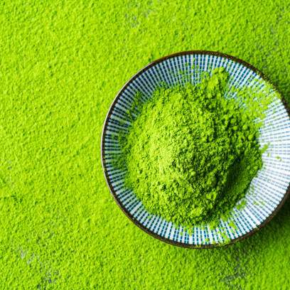 Vibrant green matcha powder in a ceramic bowl, showcasing premium Japanese tea quality