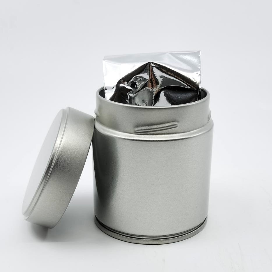 Silver tea tin with foil-wrapped Japanese tea leaves, ideal for premium tea storage