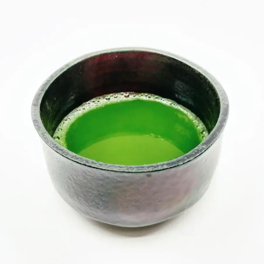 Vibrant green matcha tea in a handcrafted ceramic bowl, showcasing authentic Japanese tea culture.