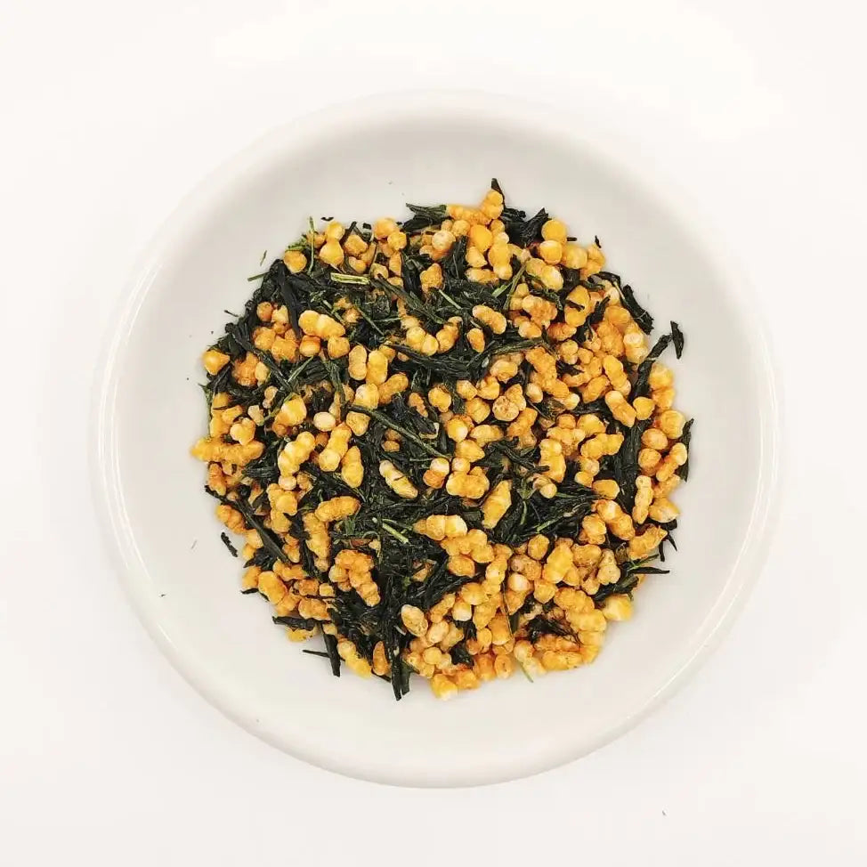 Tea leaves with yellow flowers on a white plate