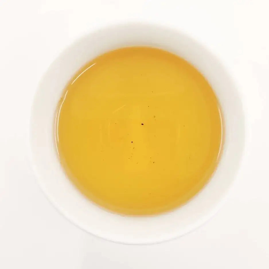 Yellow liquid in a white cup on a white background