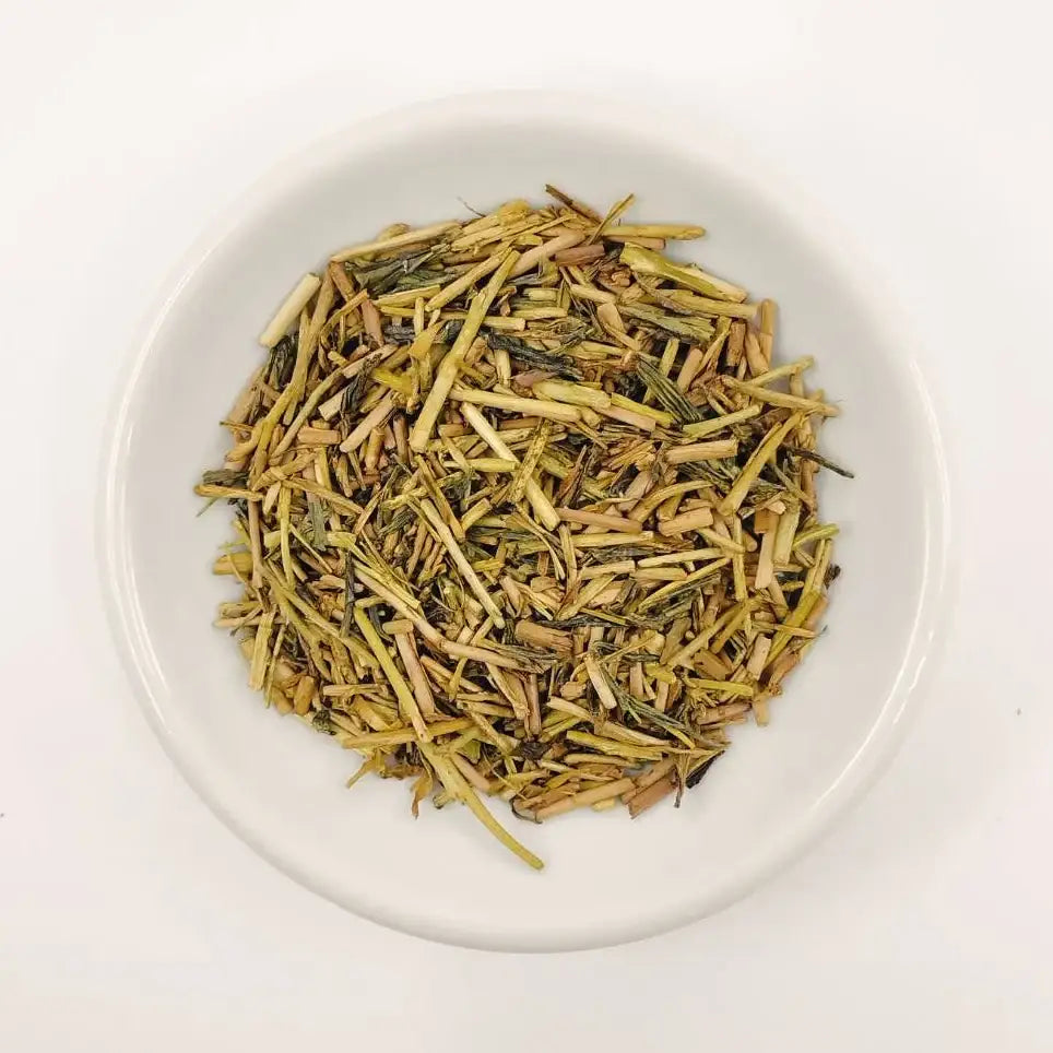Dry tea leaves on a white plate with a white background