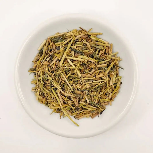 Dry tea leaves on a white plate with a white background