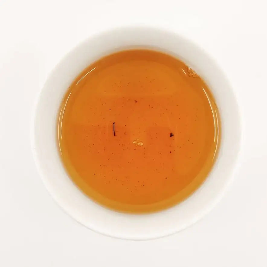 Orange liquid in a white bowl on a white background