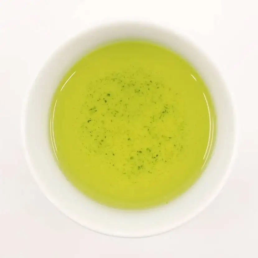 Green tea in a white bowl on a white background