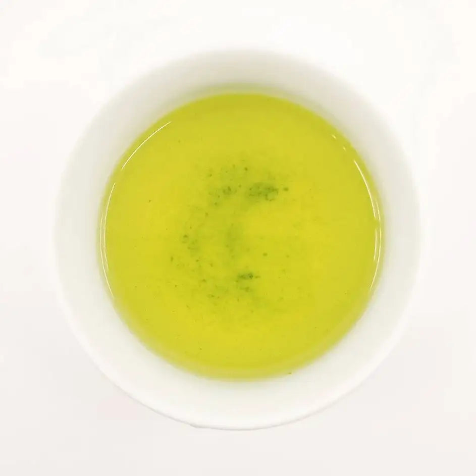 Green tea in a white cup on a white background