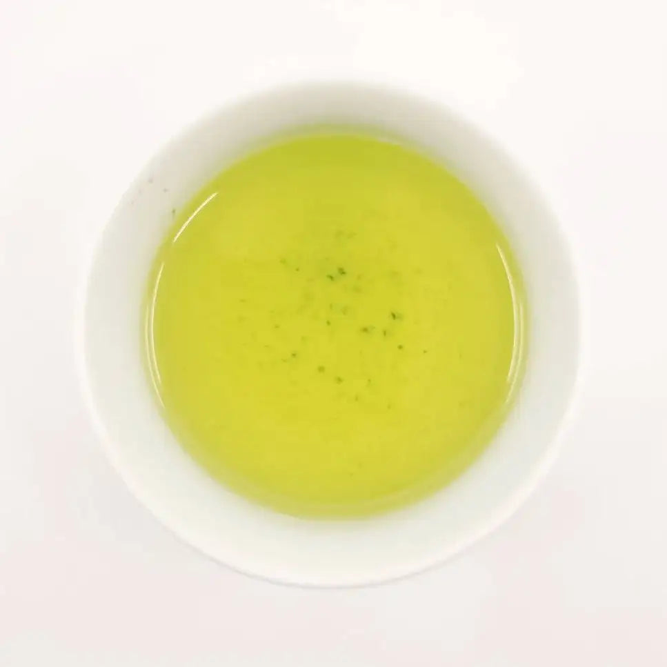 Green tea in a white bowl on a white background