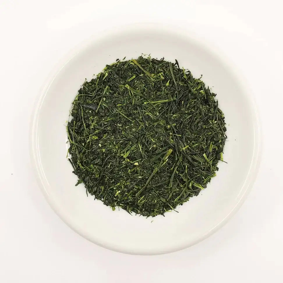 Green tea leaves on a white plate with a white background