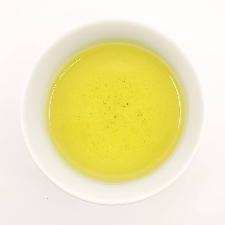 White bowl filled with yellow liquid on a white background