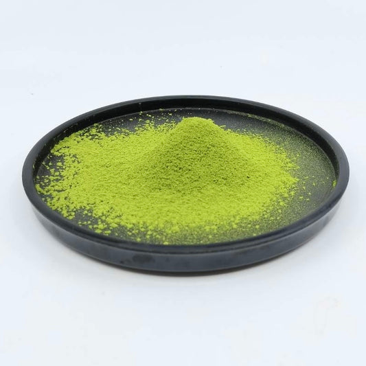 Vibrant green Japanese matcha tea powder on a black plate