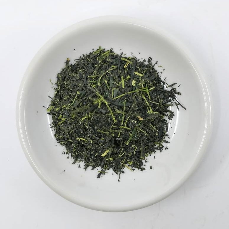 Dry green tea leaves on a white plate