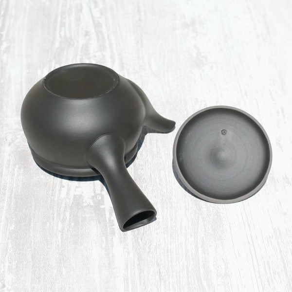 Black ceramic kyusu teapot with lid, Japanese tea ware on white wood surface