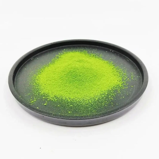 Bright green matcha powder on a black dish, premium Japanese tea powder for brewing