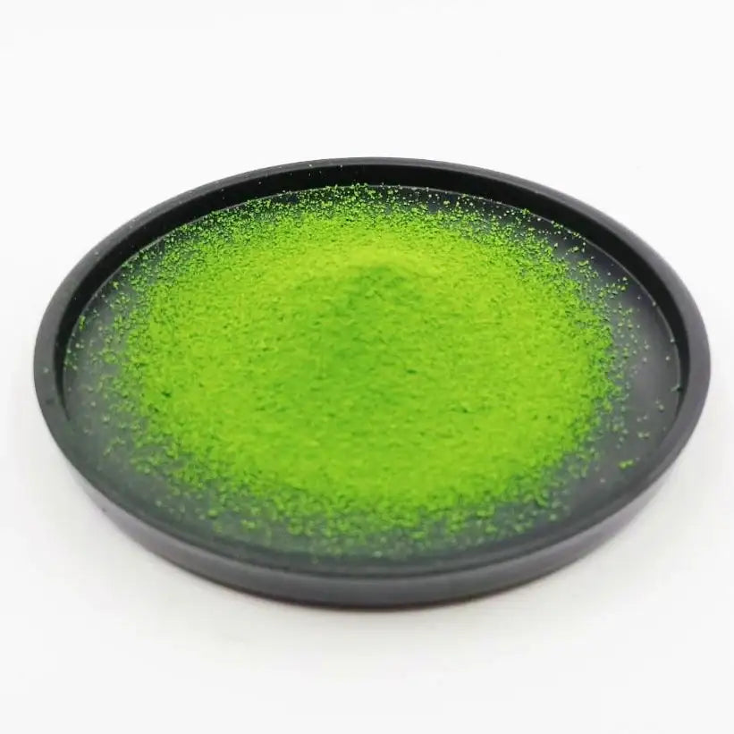 Vibrant green matcha powder in a black dish, ideal for Japanese tea ceremonies and premium tea experiences.