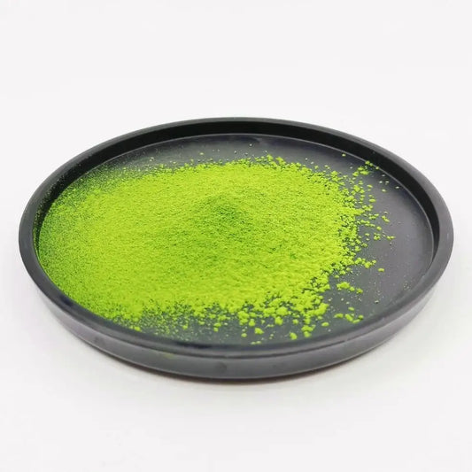 Bright green matcha powder on a black plate, premium Japanese green tea