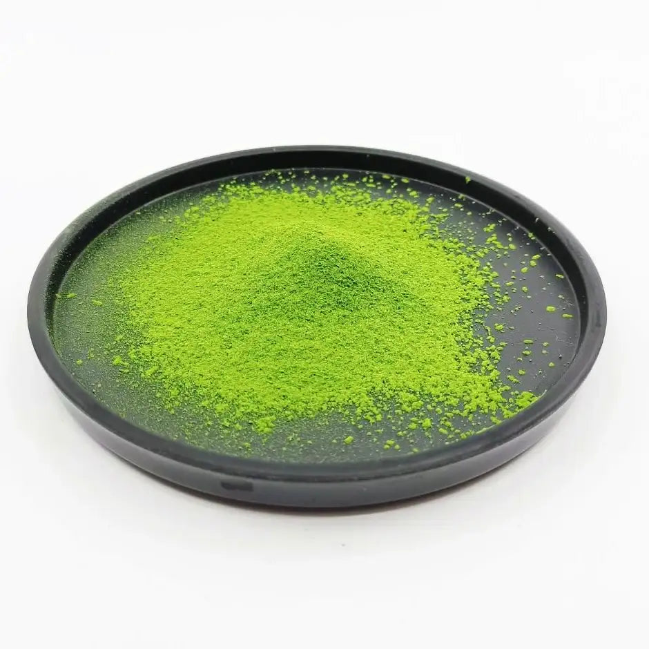 Vibrant green matcha tea powder on a black tray, premium Japanese tea product